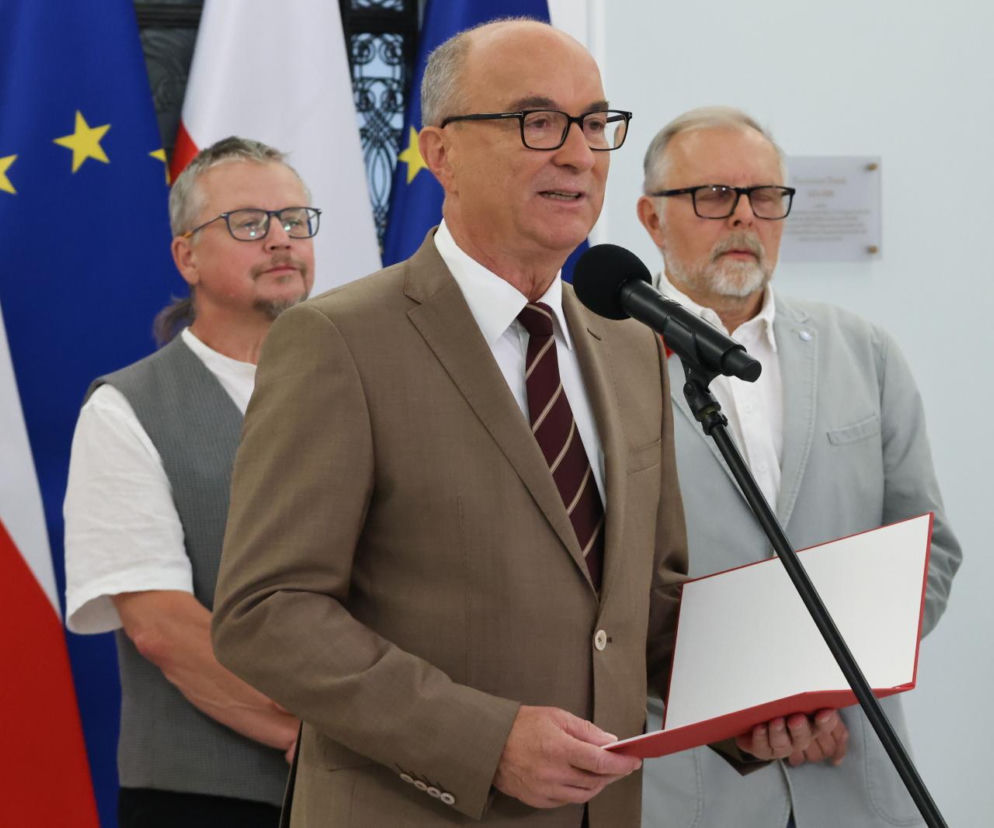 Włodzimierz Czarzasty przy mikrofonie w Sejmie na tle flag. O debacie klimatycznej przeczytasz w serwisie Eska.