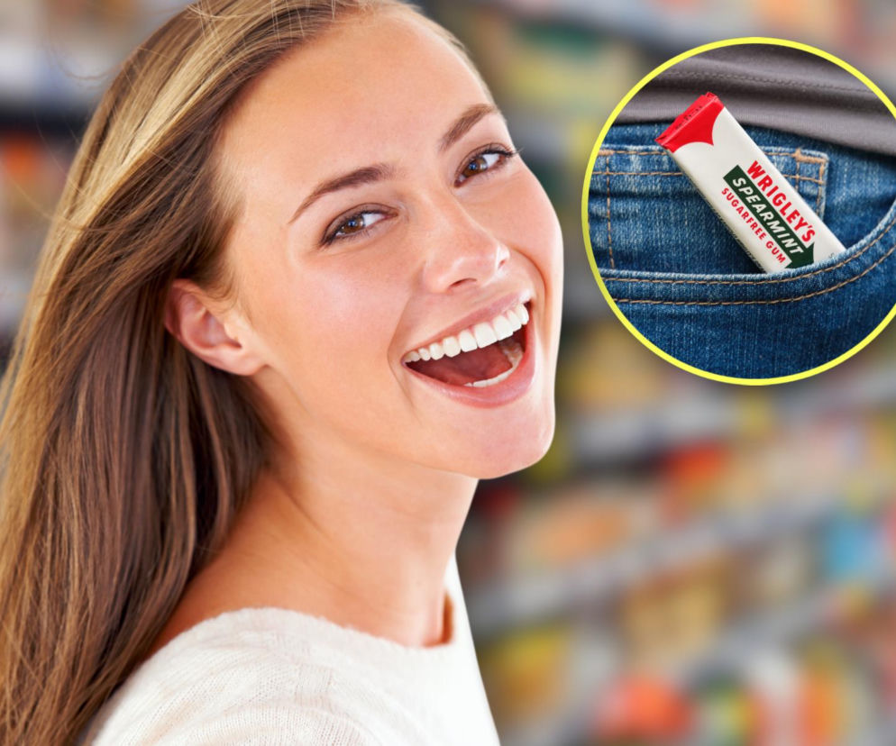 Uśmiechnięta kobieta na tle regałów sklepowych. Na miniaturze obok guma Wrigley’s Spearmint w kieszeni spodni. Czytaj na SE.