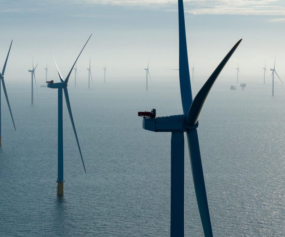 Liczne turbiny wiatrowe na otwartym morzu we mgle. O finale prac nad farmą Baltic Power przeczytasz na Eska.
