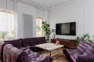 Mieszkanie w stylu modern organic z bakłażanowym kompletem sof i foteli. To duma właścicielki