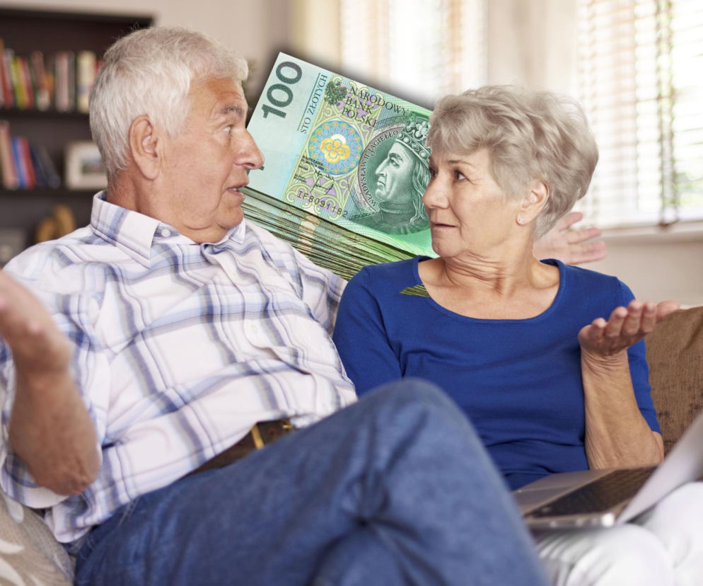 Para starszych osób siedzi na kanapie, dyskutując o finansach. Między nimi umieszczono stos banknotów stuzłotowych, symbolizujący walkę o wyższe emerytury, o czym można przeczytać na Super Biznes.