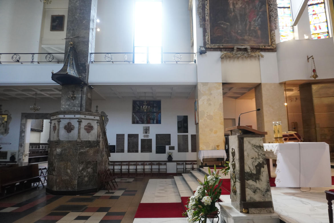 Wnętrze kościoła św. Stanisława Kostki, przed którym znajduje się nagrobek księdza