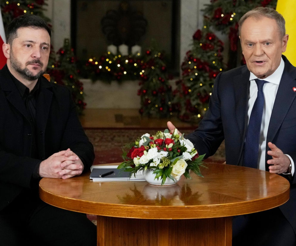 Wołodymyr Zełenski i Donald Tusk podczas spotkania, siedzą przy stole. Tusk gestykuluje, a na stole stoi bukiet biało-czerwonych kwiatów. O zmianach dla Ukraińców w Polsce i specustawie przeczytasz na Super Biznes.
