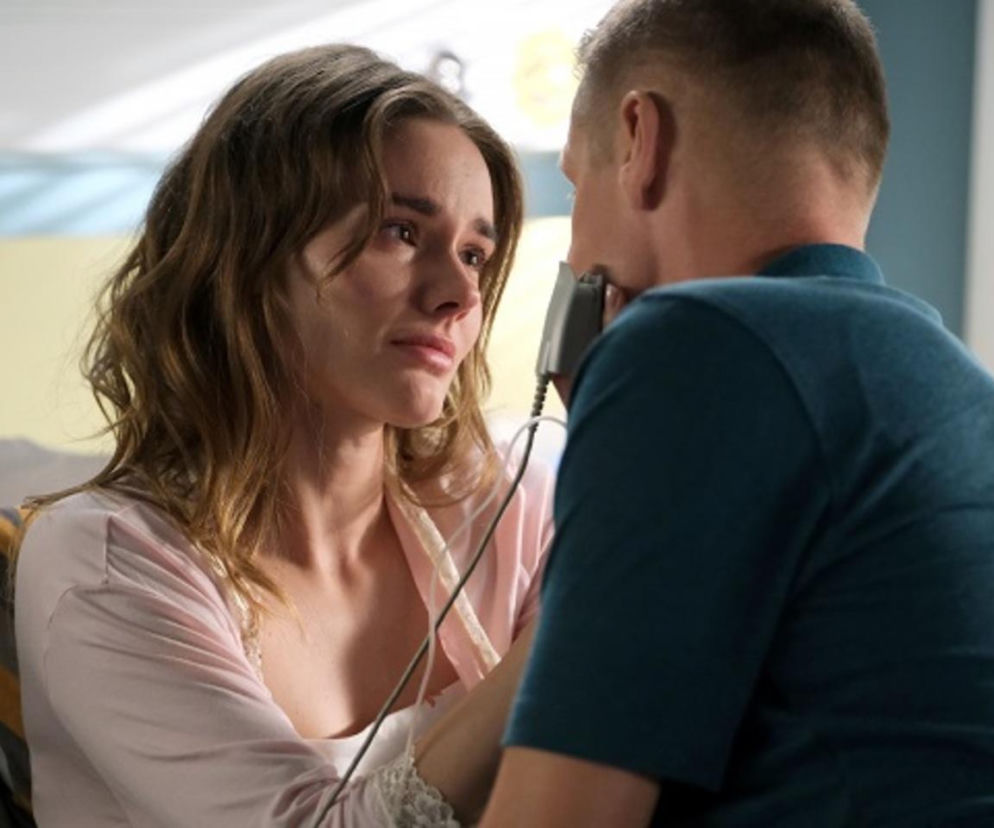 Franka (Dominika Kachlik) i Paweł (Rafał Mroczek) w dramatycznej rozmowie, Franka ze łzami w oczach słucha Pawła, który obiecuje jej wsparcie przed operacją tętniaka. Franka w różowej koszuli, Paweł w ciemnozielonej koszulce. Artykuł o serialu M jak miłość znajdziesz na Super Seriale.