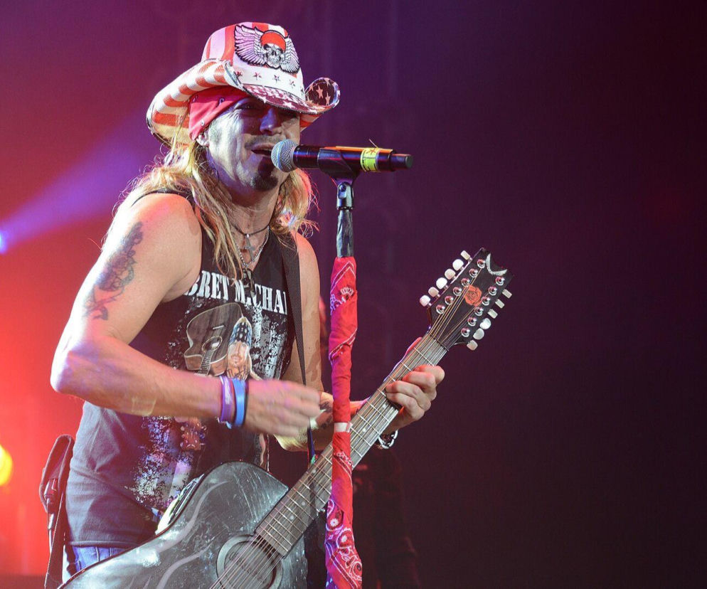Bret Michaels śpiewa do mikrofonu i gra na gitarze podczas koncertu. O zdrowiu wokalisty przeczytasz na EskaRock.