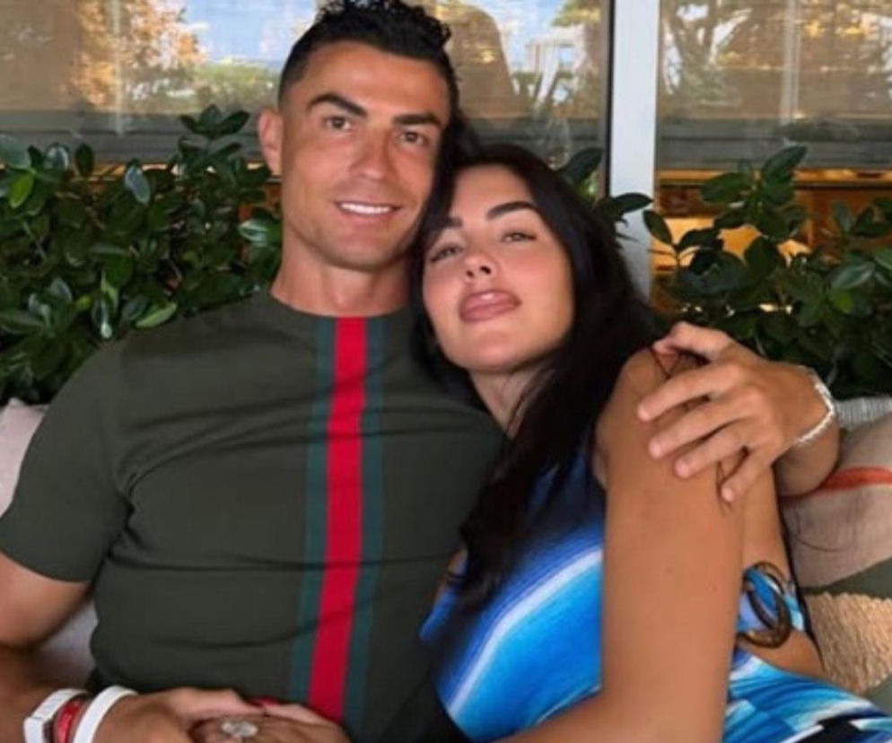 Cristiano Ronaldo i Georgina Rodriguez siedzą blisko siebie na tarasie. O ślubie pary przeczytasz na SE.