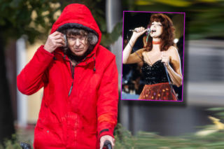 Elżbieta Dmoch porusza się o balkoniku i chowa twarz za kapturem. Chodzenie sprawia jej ból