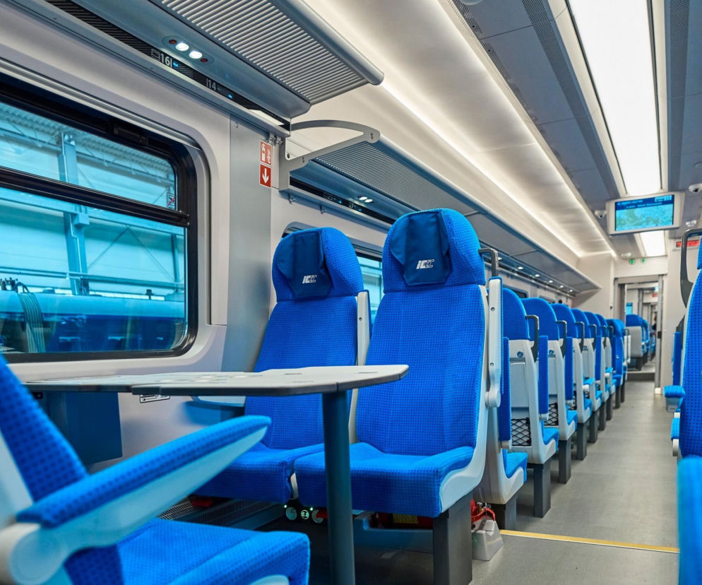 Puste, niebieskie fotele w nowoczesnym wagonie PKP Intercity. O wrażeniach turystki z USA przeczytasz na SE.
