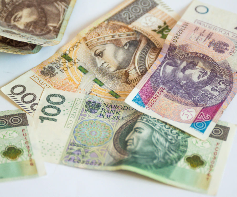 Zgromadzone banknoty polskiej waluty w różnych nominałach: 20 zł, 100 zł i 200 zł, leżące na białym tle, symbolizują zarobki i wzrost płacy minimalnej. To kluczowa informacja dla milionów Polaków, o której przeczytasz na Super Biznes.