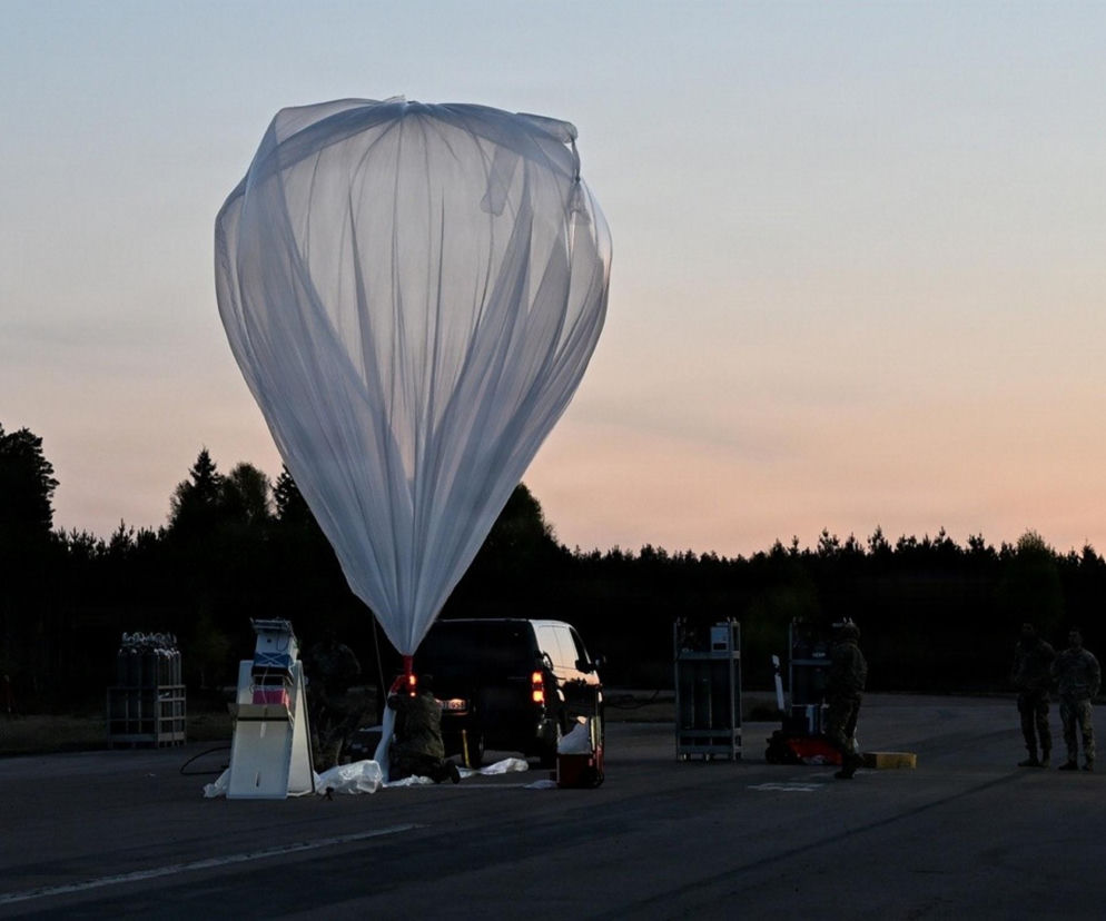 Żołnierze przygotowujący duży, biały balon stratosferyczny na asfalcie. O ćwiczeniach wojskowych przeczytasz na SE.