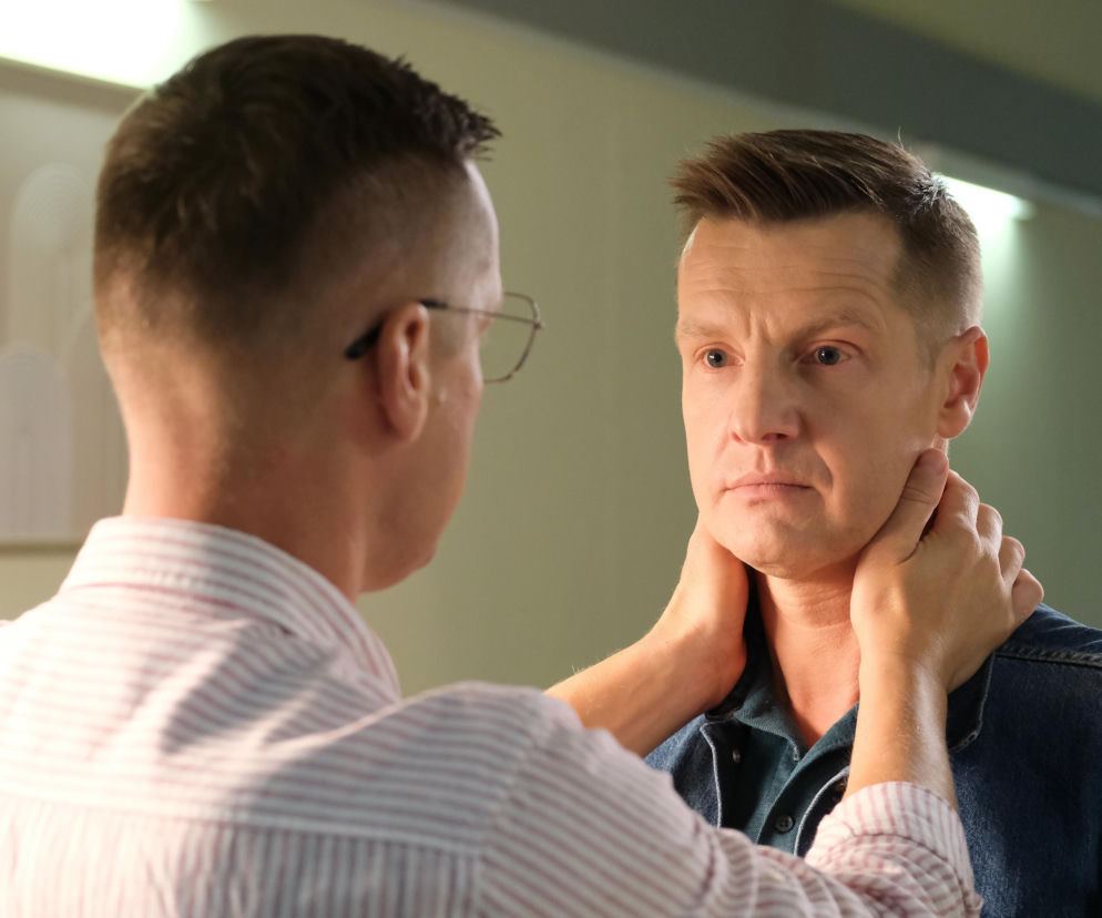 Dwóch mężczyzn, Marcin Mroczek (Piotrek) i Rafał Mroczek (Paweł), patrzących na siebie z zatroskaniem, jeden obejmuje dłońmi szyję drugiego. Scena odzwierciedla trudne chwile i emocje związane ze śmiercią Franki, poruszane na Super Seriale.