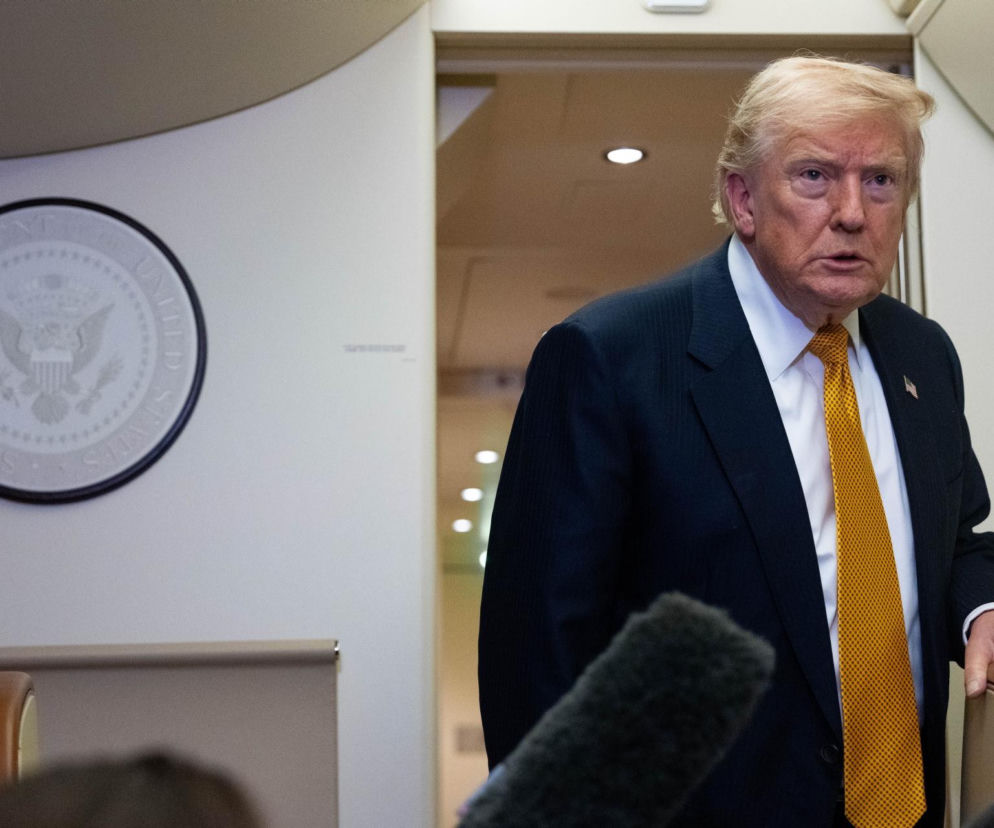 Donald Trump w ciemnym garniturze i żółtym krawacie na tle godła USA. O ataku na cele w Iranie przeczytasz na SE.
