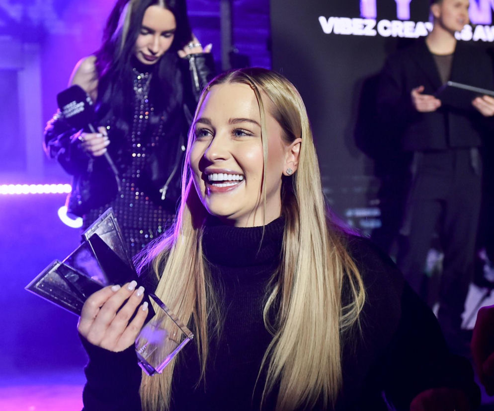 Uśmiechnięta influencerka Andziaks ze statuetką w dłoniach. O długach jej matki przeczytasz na SE.