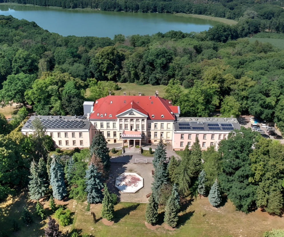 Pałac w Górznie z lotu ptaka otoczony gęstym lasem i jeziorem w tle. O skarbie w Górznie przeczytasz na Eska Leszno.