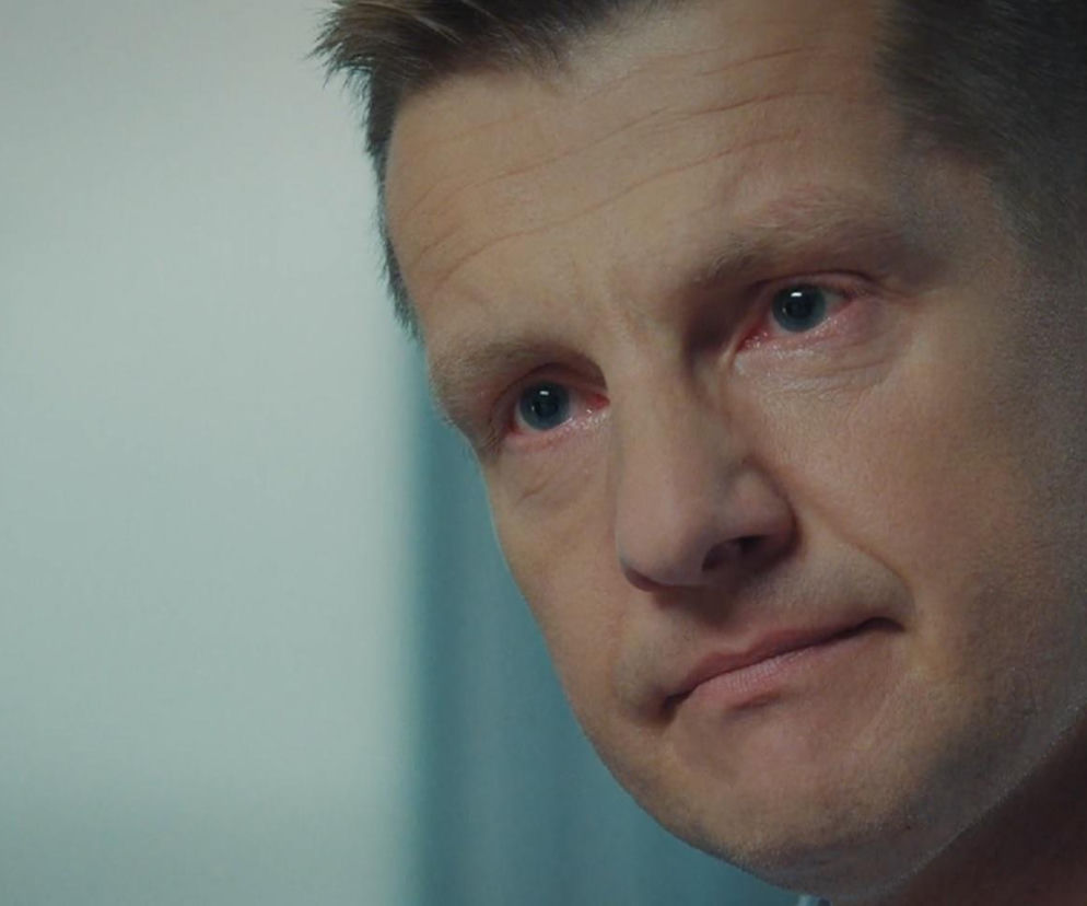 Bliskie ujęcie Pawła (Rafał Mroczek) z serialu M jak miłość w szpitalu, zmartwionego i zasmuconego, z zaczerwienionymi oczami. Emocjonalny moment serialu, o którym można przeczytać na Super Seriale.