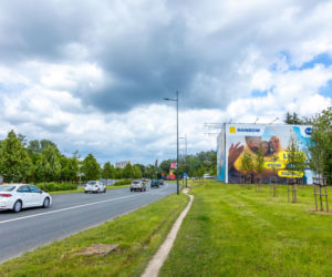 Otoczony reklamami dom przy Dolinie Służewieckiej w Warszawie