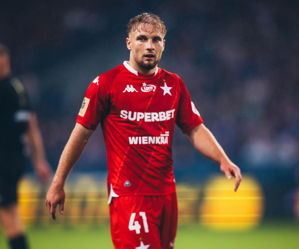 Kacper Duda w czerwonej koszulce Wisły Kraków na boisku. O jego debiutanckim golu przeczytasz na SE Supersport.