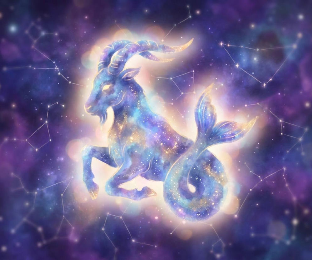 Grafika przedstawia mistyczny symbol znaku zodiaku Koziorożca z ciałem kozła i ogonem ryby, w odcieniach fioletu i błękitu, wypełniony gwiezdnym pyłem na tle rozgwieżdżonego nieba z konstelacjami. Tło rozmyte, pełne jasnych punktów, oddaje kosmiczną, eteryczną aurę, nawiązując do horoskopu dziennego, o którym przeczytasz na naszym portalu.