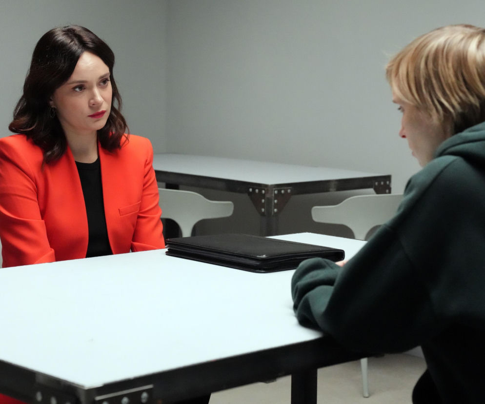 Aktorka Maria Dejmek jako Natalia w pomarańczowej marynarce rozmawia z Weroniką Nockowską jako Sonią w ciemnej bluzie podczas spotkania, siedząc przy białym stole. Scena z serialu Barwy szczęścia, której opis znajdziesz na Super Seriale.