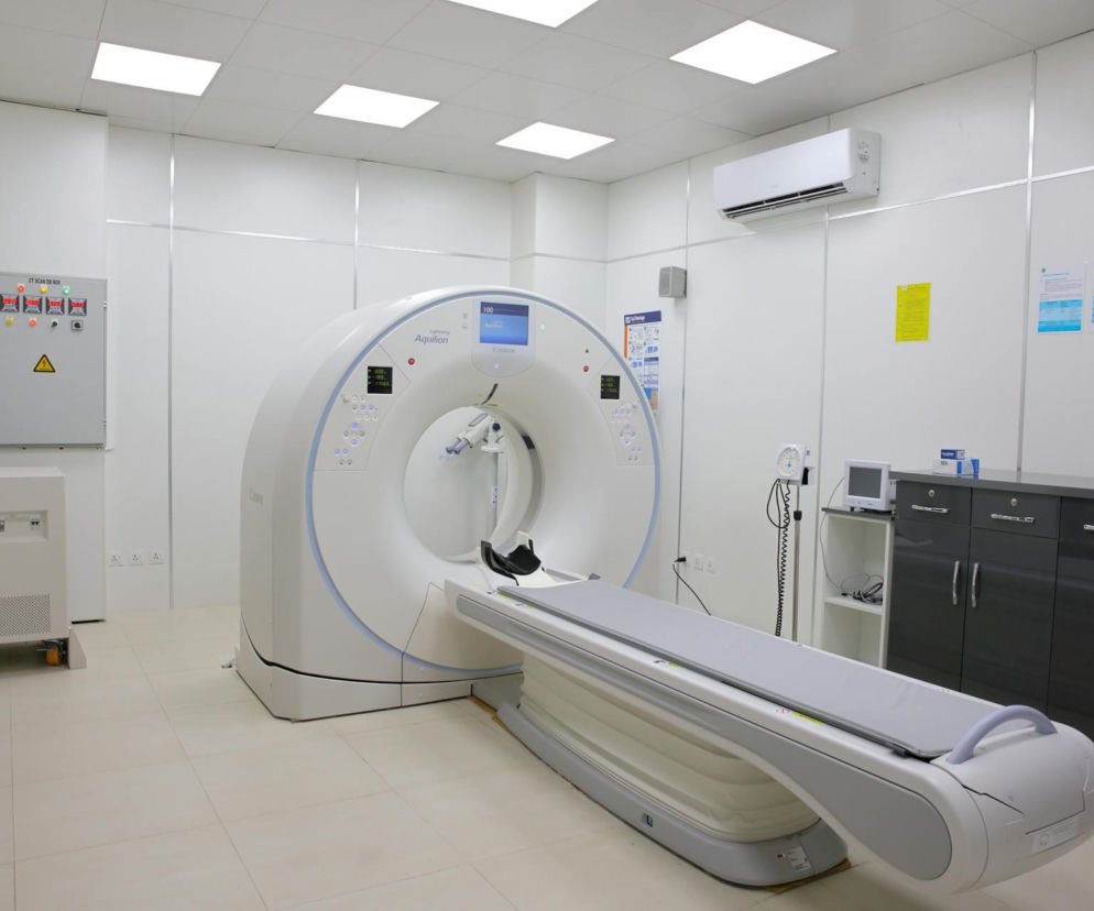 Biała, nowoczesna maszyna diagnostyczna PET-CT marki Canon Aquilion w sterylnym gabinecie szpitalnym, służąca do precyzyjnego wykrywania ognisk nowotworowych. O tym, dlaczego badanie PET-CT jest tak ważne w leczeniu onkologicznym, przeczytasz na Poradnik Zdrowie.