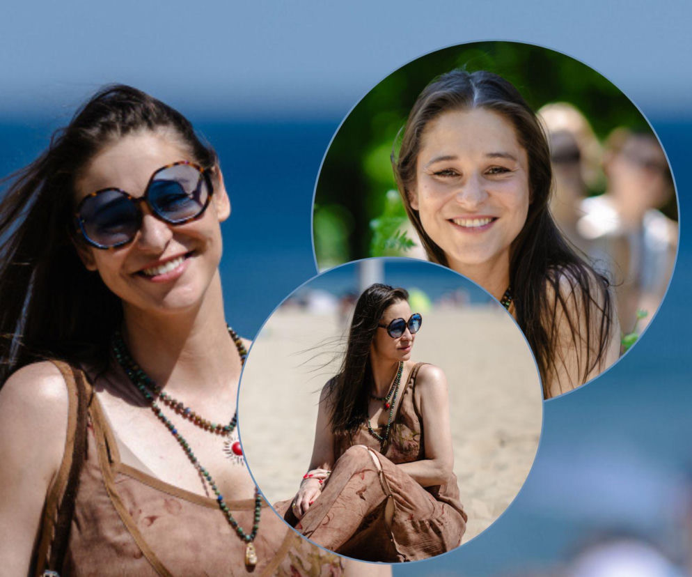 Aktorka Anna Szymańczyk w swobodnej, naturalnej odsłonie nad morzem, z uśmiechem i w ciemnych okularach, otoczona plażą i zielenią. Możesz przeczytać o jej urodzinach i sukcesach zawodowych na naszym portalu.