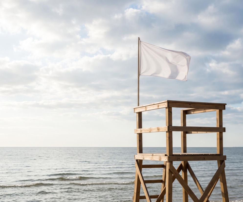 Biała flaga powiewa na wieży ratowniczej na plaży w Świnoujściu. O bezpiecznej kąpieli przeczytasz na SE Szczecin.