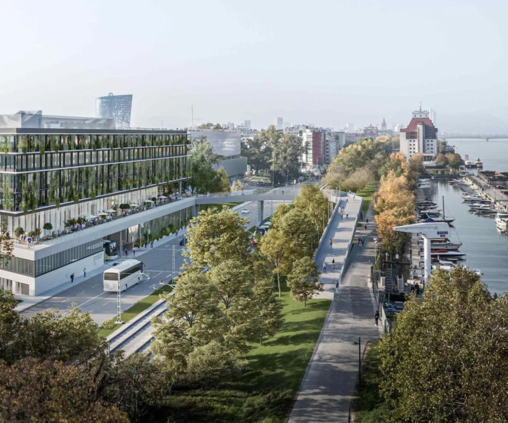 Wizualizacja nowoczesnego dworca autobusowego w Wiedniu, którego zielony dach i elewacja harmonijnie wpisują się w miejski krajobraz nad brzegiem rzeki, a o projekcie możesz przeczytać na Architektura Murator Plus.