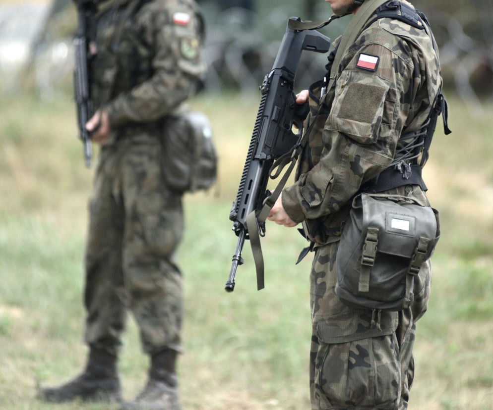Dwaj żołnierze w mundurach moro z bronią długą na polanie. O poszukiwaniach obiektu pod Lublinem czytaj w SE Lublin.