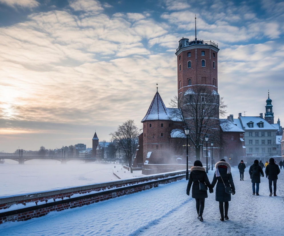 Przedstawiona scena to zimowy pejzaż miejski, gdzie dominuje pokryta śniegiem ulica i zamarznięta rzeka. Na pierwszym planie, z tyłu, idą dwie osoby, trzymając się za ręce, ubrane w ciemne, grube kurtki z futrzanymi kapturami; w oddali widać więcej pieszych. Po prawej stronie, w tle, wznosi się wysoka, ceglana wieża z małymi oknami i balkonem na szczycie, obok niej mniejsza ceglana budowla z czerwonym spiczastym dachem, wszystkie dachy i parapety budynków są pokryte śniegiem. Z lewej strony rozciąga się zamarznięta rzeka, nad którą unoszą się delikatne opary, a w dali widoczny jest most i zarys innych budynków. Niebo jest częściowo zachmurzone, z wyraźnymi promieniami słońca przebijającymi się przez chmury po lewej stronie horyzontu.