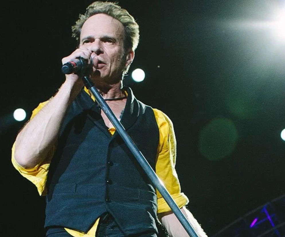 Wokalista David Lee Roth śpiewa do mikrofonu na scenie. O jego ulubionym albumie Van Halen przeczytasz na EskaRock.