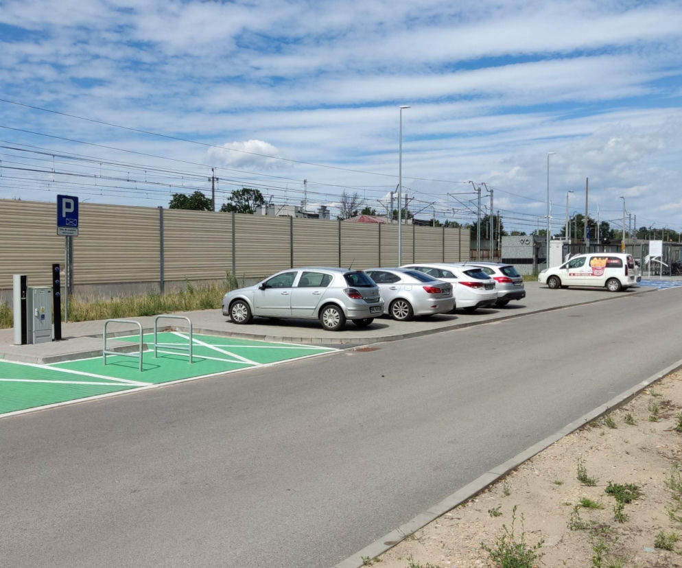 Samochody na parkingu Parkuj i Jedź przy torach kolejowych. O planach na nowe parkingi P+R przeczytasz w Architektura.