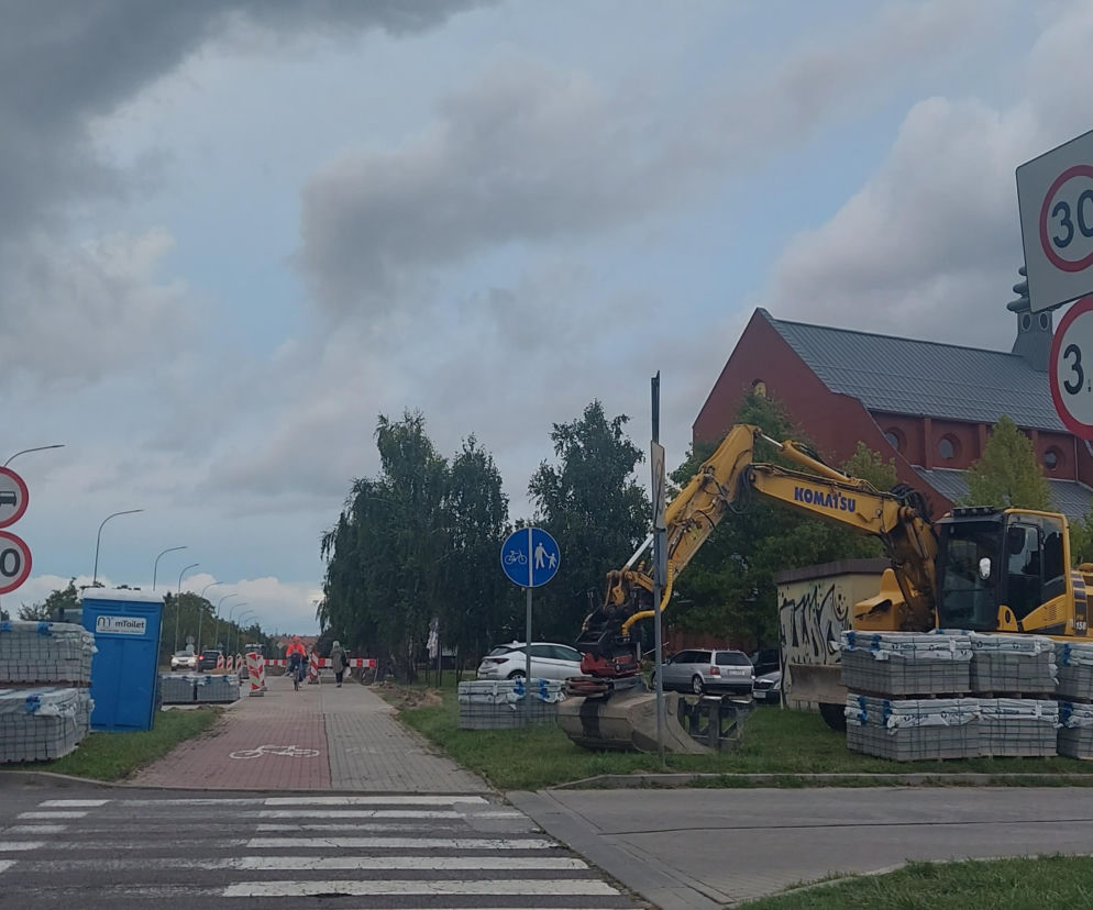 Koparka i palety kostki brukowej przy budowie parkingu w Zamościu. O szczegółach inwestycji przeczytasz na Eska Zamość.