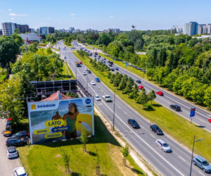 Otoczony reklamami dom przy Dolinie Służewieckiej w Warszawie
