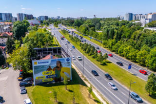 Otoczony reklamami dom przy Dolinie Służewieckiej w Warszawie