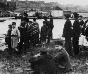 Grupa przechodniów obserwująca przypływ wody (1925)