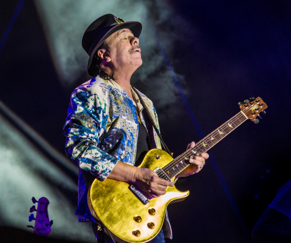 Gitarzysta Carlos Santana gra na złotej gitarze podczas koncertu. O jego wypowiedziach przeczytasz na EskaRock.