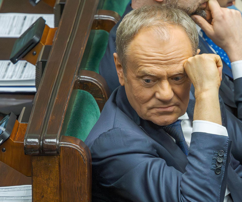 Zamyślony premier Donald Tusk siedzi w sejmowej ławie. O zatrzymaniu mężczyzny, który mu groził, przeczytasz na SE.