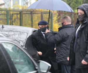 Pięciu ochroniarzy prowadzi Kaczyńskiego do bramy