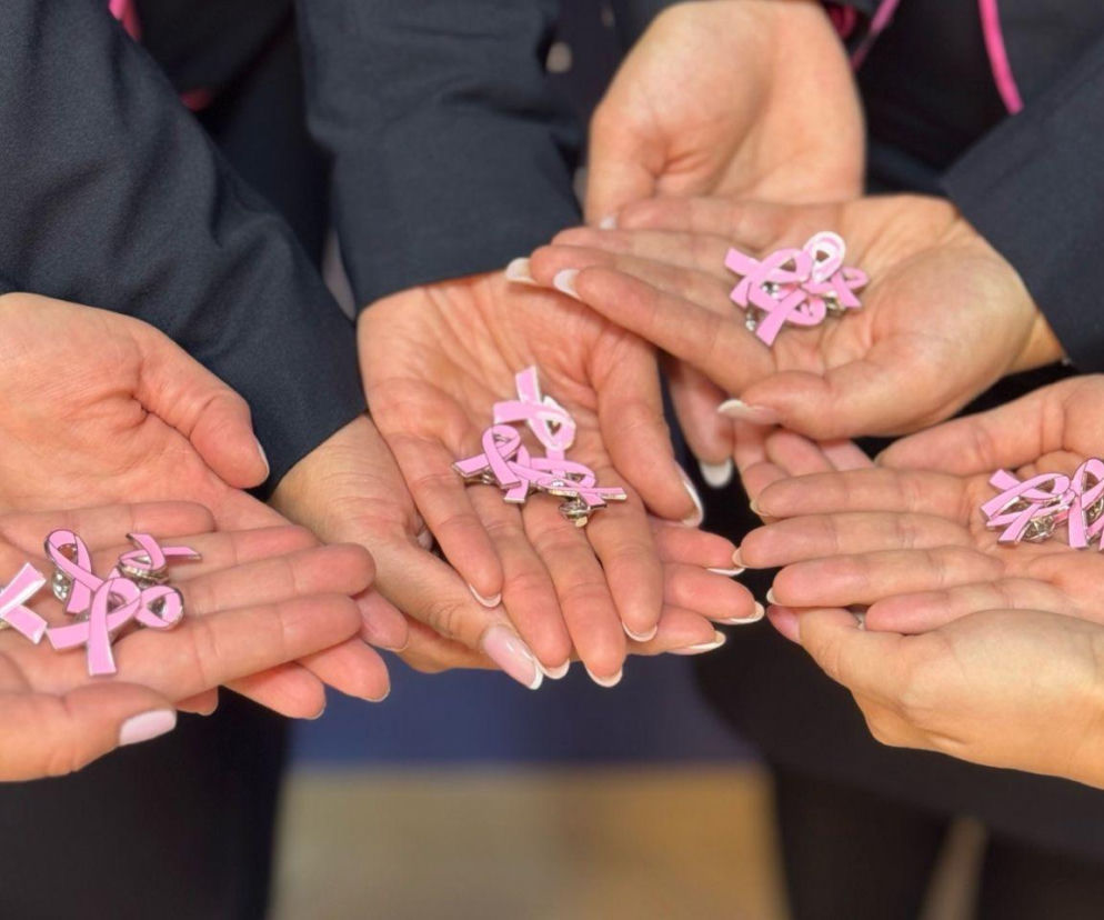 Dłonie pracowników Wizz Air trzymające różowe wstążki. O akcji Pinktober przeczytasz w serwisie Eska.