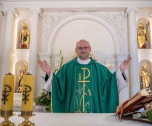 Ksiądz rozdaje pieniądze na mszy