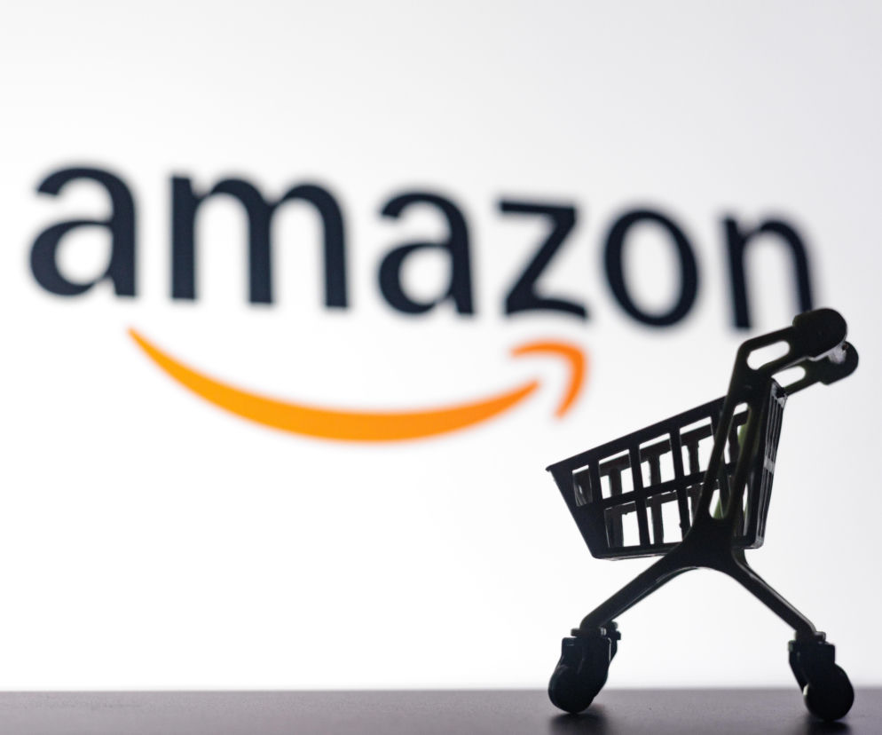 Mały wózek sklepowy na tle logo Amazon. O sukcesach polskich marek na platformie przeczytasz na SE Superbiz.