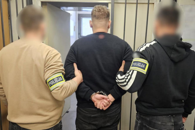 Dwaj policjanci prowadzą skutego kajdankami 34-latka. O ataku nożownika w Łodzi przeczytasz na Eska Łódź.