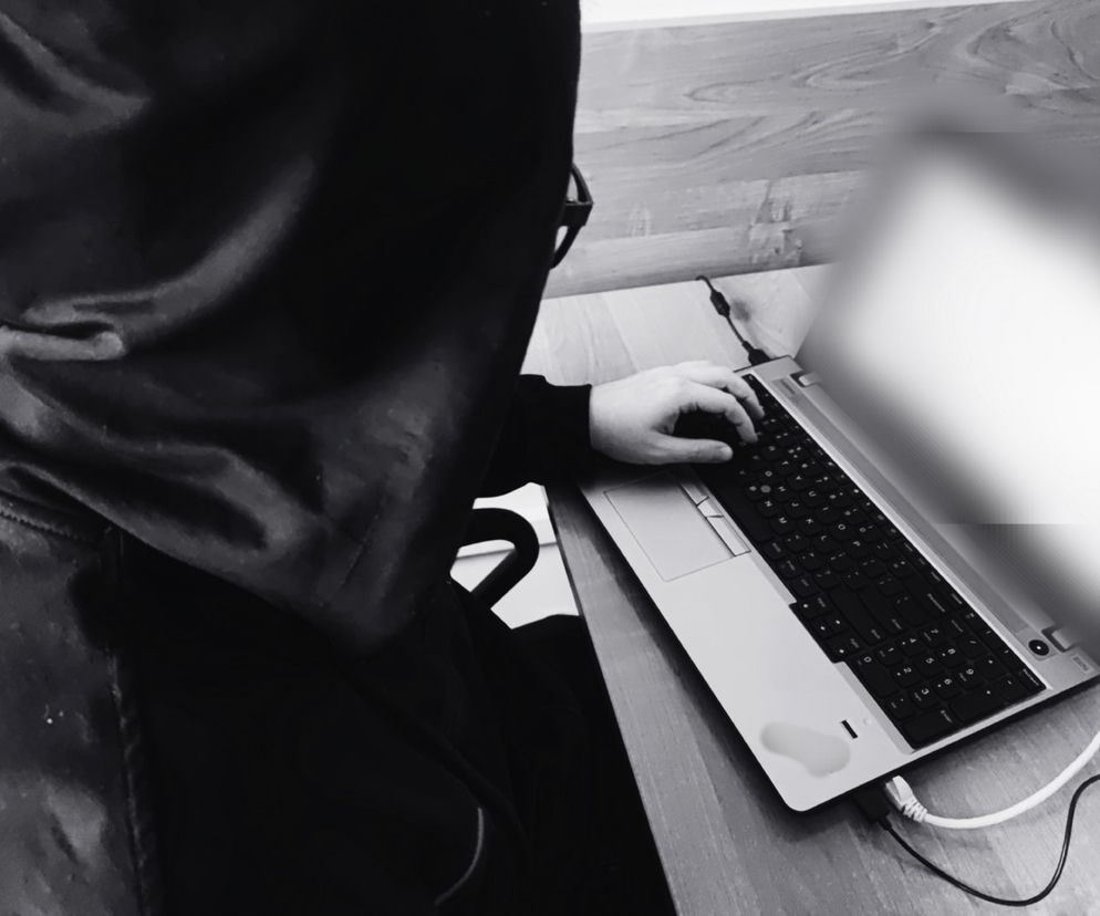 Osoba w kapturze pisze na laptopie. O akcie oskarżenia za nielegalne pliki w sieci przeczytasz na Eska Gorzów.
