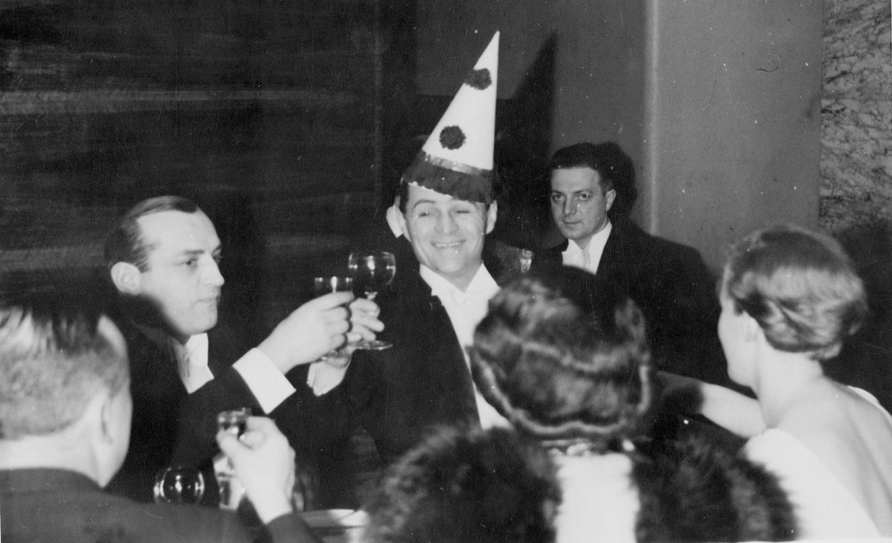 Gwiazda przedwojennej komedii Adolf Dymsza (w czapeczce) na balu w Adrii, 1935.