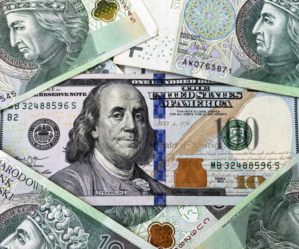 Banknot sturdolarowy z wizerunkiem Benjamina Franklina otoczony polskimi banknotami dziesięciozłotowymi, symbolizujący bieżące wahania kursów walut i osłabienie złotego, o czym przeczytasz na Super Biznes.