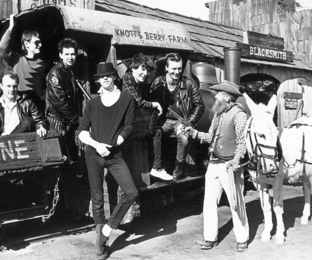 Zespół The Boomtown Rats pozuje na tle wozu kopalnianego. O historii grupy przeczytasz na EskaRock.