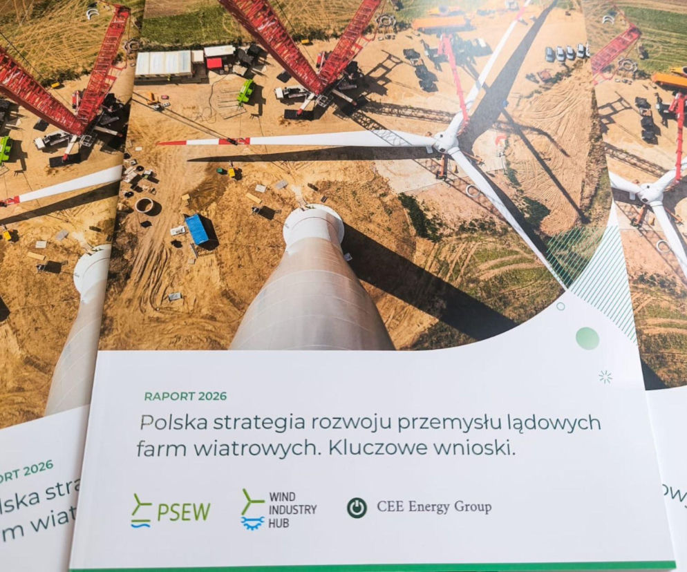 Widok z lotu ptaka na budowę farmy wiatrowej z częściami turbin i ciężkim sprzętem, podkreślający dynamiczny rozwój lądowej energetyki wiatrowej w Polsce, o której przeczytasz na Super Biznes. Zdjęcie ilustruje strategię rozwoju polskiego przemysłu OZE.