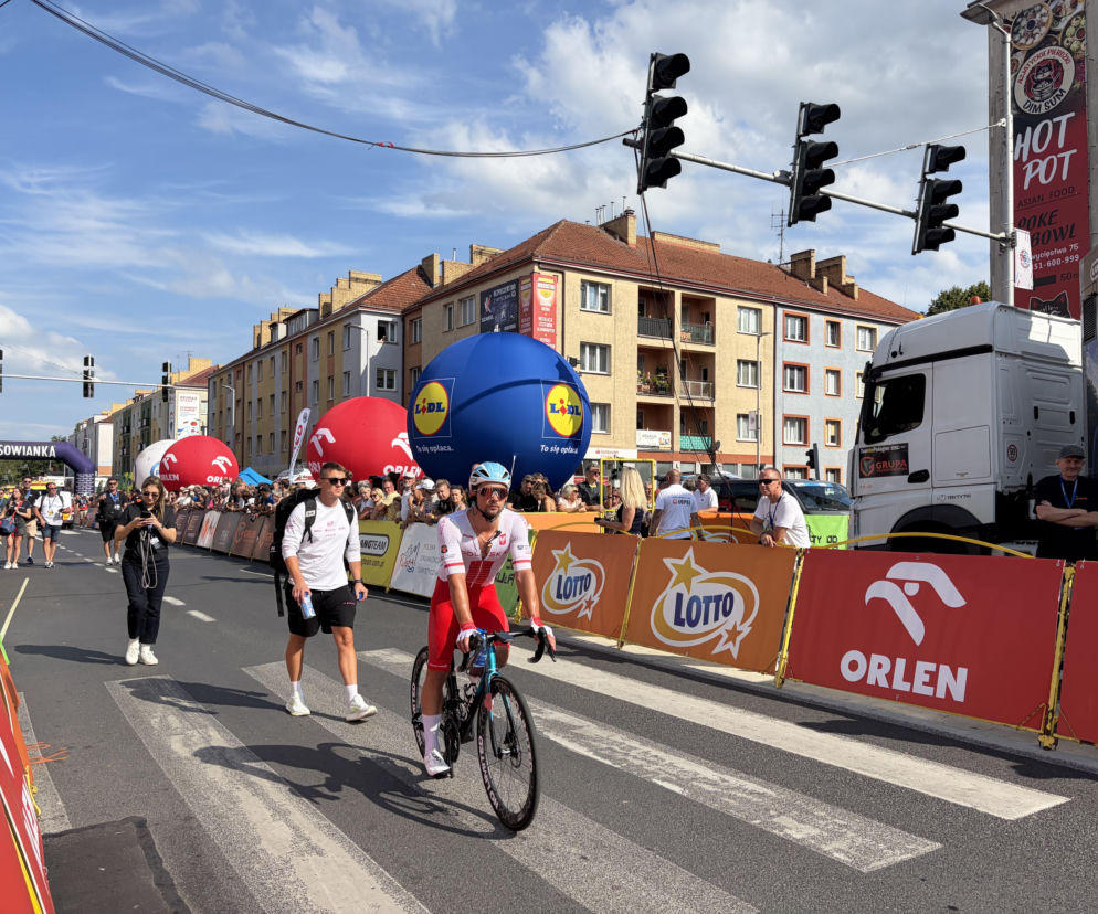 Kolarz w biało-czerwonym stroju jedzie przez miasto podczas Tour de Pologne. O trasie wyścigu przeczytasz na SE Supersport.