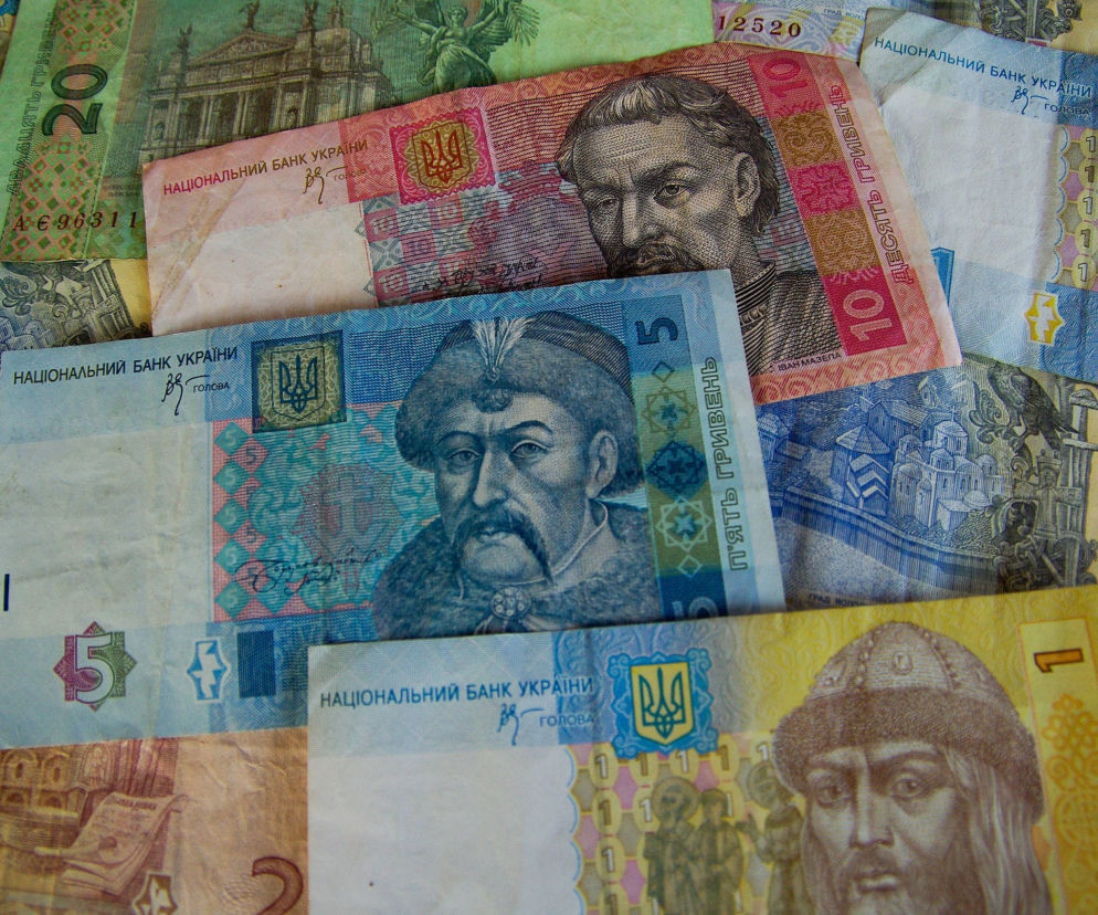 Różnokolorowe banknoty ukraińskich hrywien ułożone obok siebie. O sporze w UE o pożyczkę dla Ukrainy przeczytasz na SE Polityka.
