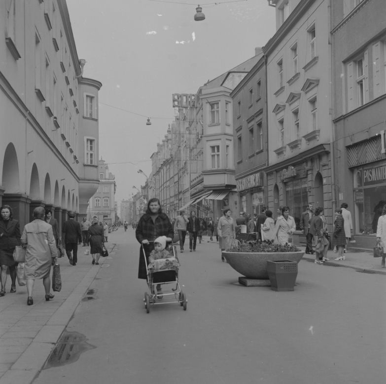 Widoczne zabytkowe kamienice. Na ulicy kobieta z dzieckiem w wózku, 1973-05-11 